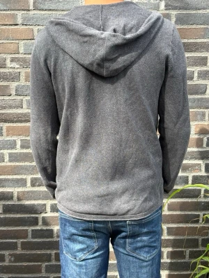 Mörkgrå zip hoodie med huva - En enkel och stilren mörkgrå hoodie med dragkedja framtill och huva med dragsko. Tillverkad i ett mjukt material som känns skönt mot huden. Perfekt att slänga på sig över en t-shirt. Passar till jeans eller joggers för en avslappnad look.. Skriv gärna vid frågor! Modell:180/70kg