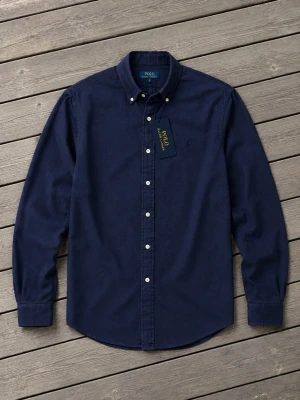 Mörkblå skjorta från Polo Ralph Lauren - Polo Ralph Lauren Custom Fit skjorta i mörkblå färg. Helt ny med originalprislapp kvar och aldrig använd. Klassisk och stilren skjorta som passar både till vardag och finare tillfällen. Storlek S med en snygg Custom Fit-passform. 📦 Skick: 10/10 – helt ny med tags. Skickas väl paketerad. Nypris: 2 195 kr – jag säljer den för endast 1 799 kr.