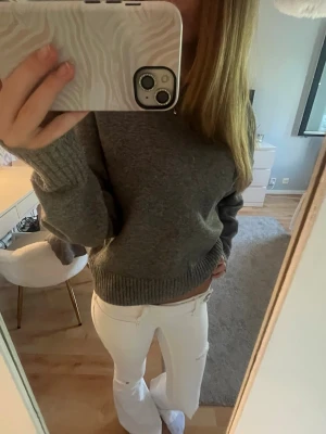 Mörkgrå stickad tröja - Mysig mörkgrå stickad tröja med rund hals och ribbade muddar vid ärmslut och nederkant. Perfekt för lager på lager och enkel att matcha med olika stilar. Tröjan har en avslappnad passform och är gjord i ett mjukt material. Lite nopprig🥰