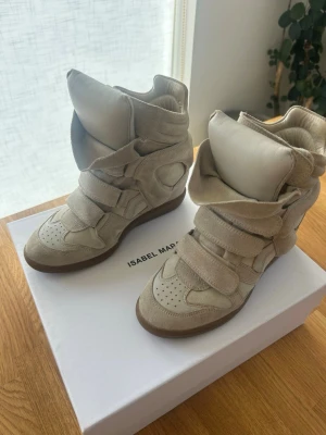 Isabel marant sneakers  - Bekett sneakers i färgen ecru och storlek 38. Säljes då de är för små. Kostar 6500 kr i nypris. De är i super bra skick med små tecken på användning som ej syns när man har på sig dem. Skopåsar och skokartong medföljer. Pris går att diskutera vid snabb affär. Skriv vid några funderingar eller för fler bilder! 