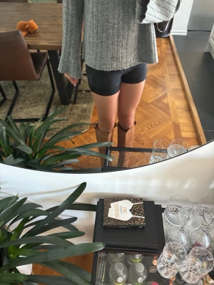 Svarta denimshorts - Säljer ett par svarta jeansshorts med hög midja och klassisk femficksdesign. Shortsen har uppvikta benslut och stängs med knapp och dragkedja. Perfekta till sommaren och lätta att matcha med olika stilar.