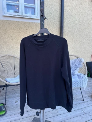 Svart sweatshirt från Stone Island - Säljer en stilren svart sweatshirt från Stone Island. Tröjan har rund halsringning, långa ärmar och ribbade muddar vid ärmslut och nederkant. Perfekt basplagg för en clean och avslappnad look. Har ändvänt två gånger så inget fel på den. Köpt för 4000 men säljer för 2700