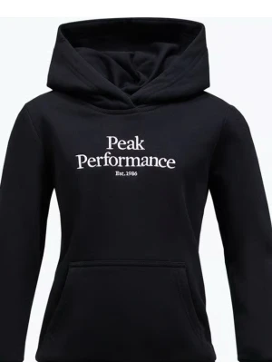 Svart hoodie Peak Performance - Snygg svart hoodie från Peak Performance med vit broderad logga på bröstet och känguruficka framtill. Klassisk modell med huva och ribbade muddar vid ärmar och nederkant. Perfekt för en avslappnad och sportig stil.