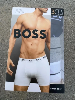 Vita boxer briefs från BOSS - Säljer ett 3-pack vita boxer briefs från BOSS i stretchig bomull. Klassisk design med resår i midjan där BOSS-loggan syns tydligt. Perfekta för dig som vill ha bekväma och stilrena kalsonger i vardagen.