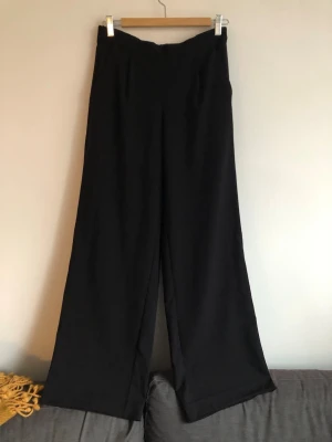 Kostymbyxor  - Svarta finbyxor stl 36. De har använts av en längre person så de är utlagda nertill. Innerbenslängden mäter 80 cm.