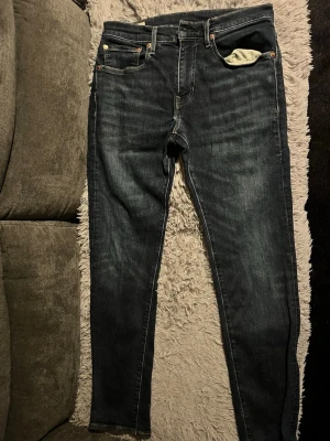 Levi's 511 mörkblå skinny jeans - Snygga Levi's 511 jeans i mörkblå tvätt med klassiska fem fickor och läderpatch bak. Jeansen har en slim och skinny passform med smala ben och är tillverkade i stretchig denim för extra komfort. Perfekta för dig som gillar en modern och stilren look.