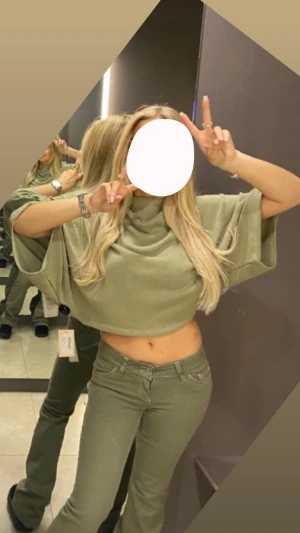 Olivgrön croppad polotopp nelly - Säljer en olivgrön croppad polotopp med breda, korta ärmar och hög krage. Toppen har en loose passform och är tillverkad i ett mjukt, stickat material som ger en chill vibe. Perfekt för dig som gillar att sticka ut med coola silhuetter. kom privat för bättre bilder