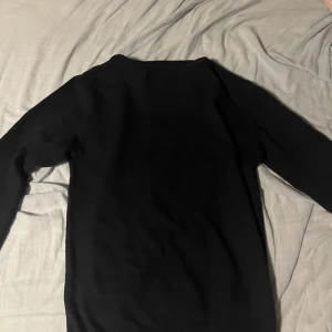 Svart stickad tröja Yves Enzo Paris - Marinblå cashmere  tröja från Yves Enzo Paris med klassisk rund hals och långärmad design. Enkel och stilren modell som passar perfekt till jeans eller chinos. Mjuk och bekväm kvalitet med ribbade muddar vid hals och ärmslut.Skriv prisförslag 