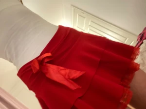 Röd volangkjol med rosett och spets - Supersöt röd kortkjol med volanger och en stor rosett framtill. Kjolen har spetskant i matchande röd färg och är gjord i ett mjukt, lätt material som känns skönt mot huden. Kjolen har många lager för bra volym och en rund siluett. Jättefin och perfekt nu till jul. 💕Står ingen storlek men är väldig stretchig så passar nog XXS-M