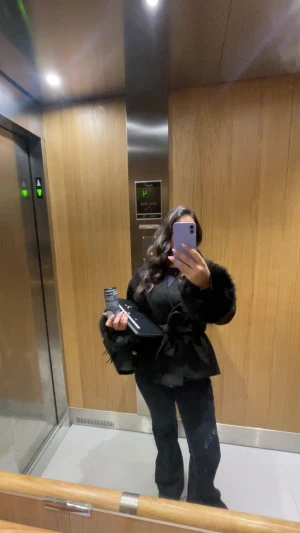 Svart pälsjacka med bälte från Gina Tricot - Säljer en svart pälsjacka från Gina Tricot med fluffiga fuskpälsdetaljer vid ärmsluten och knytbälte i midjan. Jackan har en omlottstil och är långärmad med en loose passform. Perfekt för dig som vill ha en trendig och mysig look.