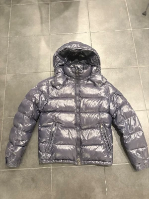 Moncler Maya Navy Blue - Säljer min Moncler Maya då den inte kommer till användning längre. Jackan är äkta vilket kan bevisas vid intresse. Cond: 8/10, enda defekten är att tvättrådet börjat släppa. Jackan är i storlek 2 och passar S/M. Jackan har nyligen varit på kemtvätt. 