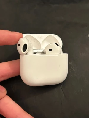 Apple AirPods 4 - Apple AirPods (4 gen) med laddningsetui. Trådlösa hörlurar med smidig anslutning till iPhone och andra Apple-enheter. Har garanti till 2026-04-09. Perfekt för musik, samtal och röststyrning via Siri. Med nypris 1600-1900kr