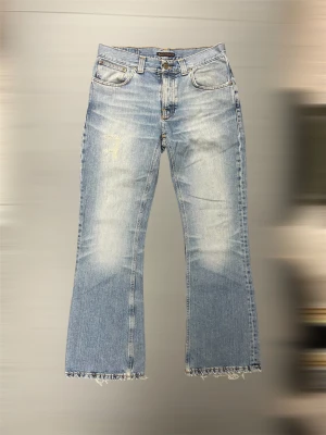 Vintage Nudie Jeans Low Flare Glenn - (Bootcut/Flare)  Riktigt schyssta och sällsynta vintage Nudie jeans i modellen ”Low Flare Glenn” vilket är den äldre modellen av den som finns uppe på nudies hemsida just nu. Från 2004. Riktigt schysst fade och slitningar, se bilder🔥. Storlek 33 i midjan men känns mer som en W31 eller W32. Svårt att fånga på bild men de är ännu snyggare i verkligheten. Se mått nedan, och läs noga för jag gör ej returer.   Midja: 42 cm Ytterbenslängd: 106 cm  Benöppning: 24,5 