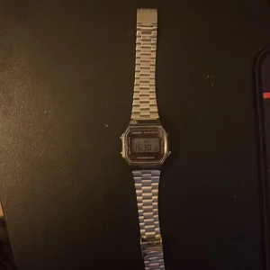 Casio digital klocka silver - Klassisk digital klocka från Casio i silverfärg med rektangulär urtavla och länkarmband i metall. Modellen är A168WE och har tydlig digital display, belysning och vattenresistens. Perfekt för dig som gillar retrostil och enkelhet.