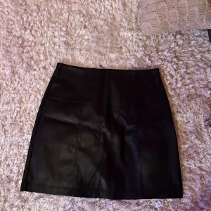 Svart kjol i läder imitation  - Snygg svart kjol. Använd ett fåtal gånger. 