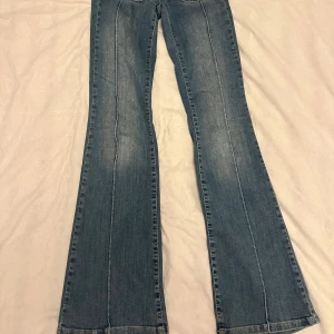 Blå bootcut jeans från Nelly - Snygga blå jeans från Nelly med Low waist bootcut-modell och klassisk femficksdesign. Jeansen har markerade sömmar längs benen och en cool tvättad look. Perfekta för dig som gillar en retrostil med lite utsvängda ben. Är 168 som referens 