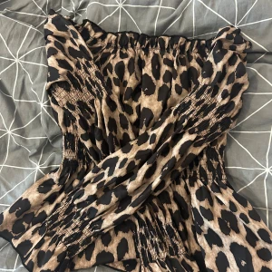 Leopardmönstrad offshoulder blus - Säljer en snygg offshoulder blus med leopardmönster i beige och svart. Materialet är lätt och luftigt, perfekt för att sticka ut med coola vibes.