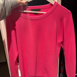 Stickad rosa tröja från French collection - Säljer en stickad tröja i stark rosa färg French collection. Tröjan har rund halsringning, långa ärmar och ribbade muddar vid hals och nederkant. Perfekt för dig som gillar färg och vill ha en enkel men snygg look.