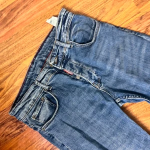 Blå skinny jeans från Dsquared2 - Säljer ett par blå skinny jeans från Dsquared2 i klassisk femficksmodell. Jeansen har snygga slitningar, röda sömmar på insidan och en liten Dsquared2-logga vid fickan. Tillverkade i mjukt denimtyg med smal passform och normal midja.