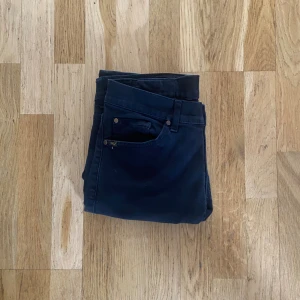 Blå skinny jeans från Nudie Jeans - Säljer ett par mörkblå skinny jeans från Nudie Jeans i modellen Tight Long John. Klassisk femficksdesign, snygga slitningar och orange sömmar. Jeansen är i stretchigt bomullsmaterial och har en smal passform som sitter fint hela vägen ner.  Aldrig använda skick 9/10 Nu pris 1300kr mitt pris 400kr🤩