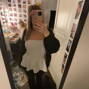 Vit peplum tubtopp - Säljer en vit tubtopp med peplumvolang nedtill. 