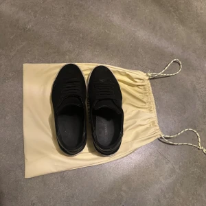 Axel Arigato. Har inte använt dom mycket, med påsen, inför vintern, snabb leverans. - Snygga svarta sneakers från Axel Arigato med klassisk rund tå och platt vit sula. Skorna har snörning och är tillverkade i mocka för en stilren och modern look. Kommer med original dustbag i ljusbeige. Perfekta för dig som gillar minimalistisk design.