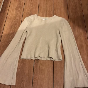 Beige topp  - En beige topp med vida armar. 