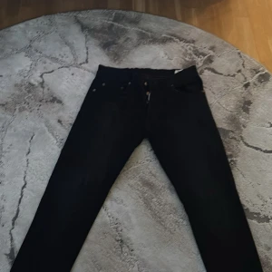 Svarta jeans från Dsquared2 - Säljer ett par svarta jeans från Dsquared2 med klassisk femficksdesign och smal passform. Jeansen har en stilren look med diskret logga bak i midjan och är tillverkade i ett stretchigt bomullsmaterial för extra komfort.
