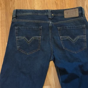 Diesel Larkee jeans blå W32 L32 - Säljer ett par klassiska blå Diesel Larkee jeans i storlek W32 L32. Jeansen har raka ben, fem fickor och snygga kontrastsömmar. Perfekta för dig som gillar en tidlös denimlook med lite bredare passform.