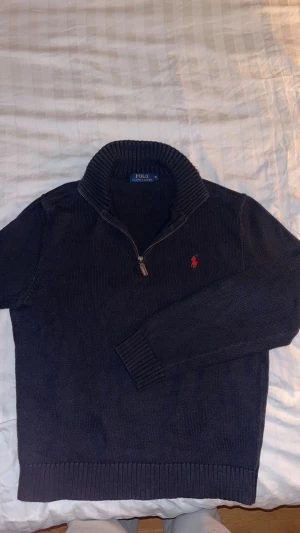 Mörkblå stickad halvzip Ralph Lauren - Skön stickad halvzip från Ralph Lauren i en vintage vibe, storleken är small men skulle passa en som har xs. Vid fler frågor eller bilder är det bara att höra av sig!