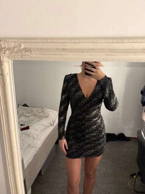 Svart glittrig omlottklänning - Helt ny Supersnygg svart kort omlottklänning (Är storlek L men är mindre i storleken skulle säga M) den har prislapp kvar 