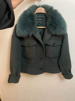 Mörkgrön pälsjacka från Meotine - Säljer en mörkgrön jacka med av och påtagbar päls från meotine! Den är i bra skick förutom några solfläckar men det är inget man lägger märke till när jackan är på. Skriv för fler bilder eller frågor!🩷Jag tar emot bud 