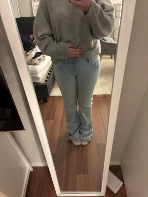 Ljusblå bootcut jeans från H&M Divided - Snygga ljusblå jeans från H&M Divided i bootcut-modell med klassisk femficksdesign. Jeansen har normal passform och är tillverkade i jeansmaterial. Perfekt för dig som gillar retrovibbar och vill ha ett par jeans med lite extra sväng i benen. MIDJEMÅTT 84cm. INNERBENSLÄNGD 81cm.