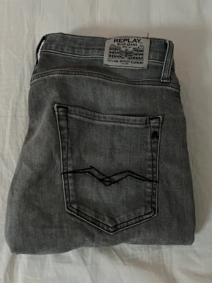 Replay grå jeans straight fit - Snygga grå jeans från Replay med klassisk femficksdesign och svarta detaljer på bakfickorna. Jeansen har rak passform och normal midja. Det står att de är 166 cm men tror de skulle passa någon över 170cm (de är väldigt långa)
