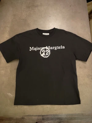 Maison Margiela svart t-shirt - I princip i nytt skick, använd endast ett fåtal gånger. Storlek M, passar riktigt snyggt. Vid extra frågor är det bara att skicka ett pm!