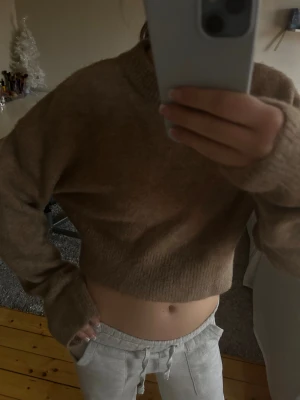Beige croppad stickad tröja från Zara - Supermysig beige croppad stickad tröja från Zara. Tröjan har en rund halsringning, långa ärmar och ribbade muddar. Perfekt för lager-på-lager och chill dagar. Passformen är loose och den är riktigt skön att ha på sig.