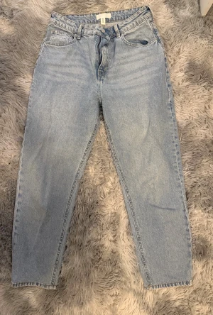 Ljusblå raka jeans i hög midja, strl 40 - Ljusblå mom jeans från H&M i klassisk modell. Jeansen har hög midja, raka ben. 