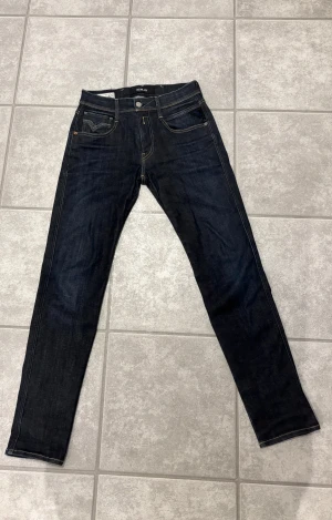 Mörkblå Replay jeans, storlek 27/30 - Tja, Replay anbass hyperflex i storleken 27/30. Väldigt bra skick då de har använts sparsamt. Snygga bakfickor och väldigt sköna att bära med hyperflexen 