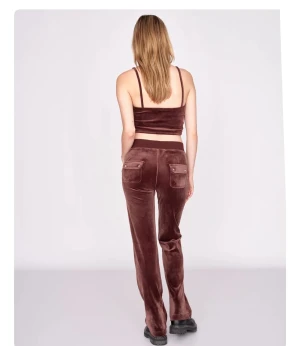 Bruna mjukisbyxor från Juicy Couture - Säljer ett par bruna mjukisbyxor från Juicy Couture i mjuk sammet. Byxorna har normal passform, raka ben och snörning i midjan. Fickor fram och bak med knappdetaljer ger en cool vibe. Perfekta för chill dagar och snygga med chunky boots.