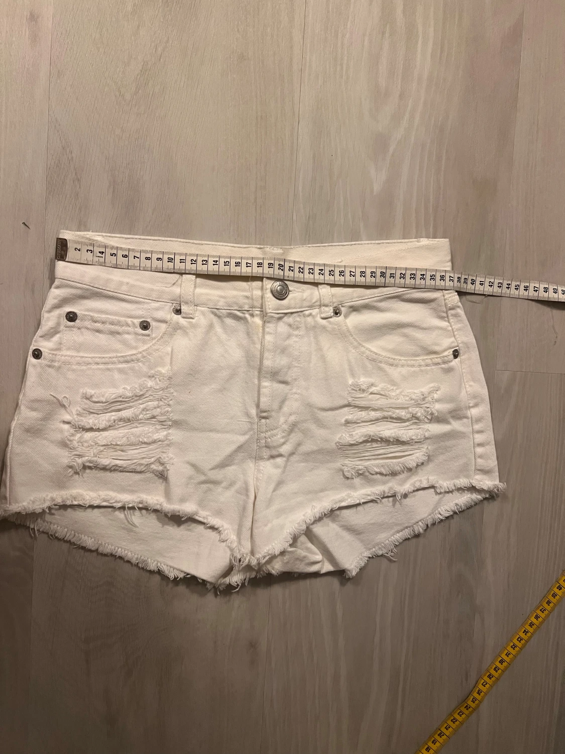 Vita högmidjade jeansshorts med slitningar