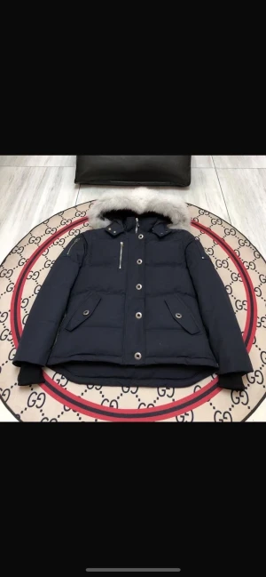 Moose knuckels - Säljer en svart Moose knuckels dunjacka med fluffig ljus päls runt huvan. Jackan har flera fickor med knappar och dragkedja, samt ribbade muddar vid ärmsluten. Perfekt för kalla dagar och riktigt snygg till vinterlooken.