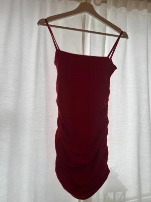 Tajt röd klänning  - En fin röd klänning med resår på sidorna, perfekt till jul