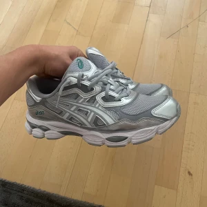 Gråa Asics Skor - Säljer ett par snygga Asics sneakers i silver och grått med vit sula. Väldigt lite använda, Mycket fint skick