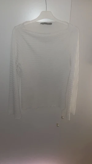 Vit ribbad långärmad tröja - Säljer en vit långärmad tröja med ribbad struktur. Tröjan har en enkel och clean design med rund hals och smal passform. Perfekt för dig som gillar stilrena och minimalistiska plagg. Passar till många olika looks och är lätt att matcha.