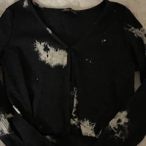 Svart och vit kofta från SHEIN - Cool svart kofta från SHEIN med vit batikmönster och ribbad struktur. V-ringad med knappar framtill och långa ärmar. Perfekt för dig som gillar en edgy och trendig stil.