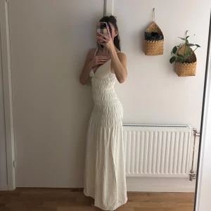 Zara Vit långklänning - Vit långklänning med v-ringad front och tunna axelband. Mjukt material med elegant. 