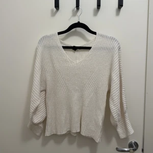 Vit ribbad stickad tröja Lindex - Säljer en vit stickad tröja från Lindex i storlek M. Tröjan har ribbad struktur, v-ringad hals och långa ärmar med lite loose passform. Perfekt för dig som gillar enkel och stilren design med mjukt material.