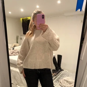 Beige stickad oversized tröja - Supermysig beige stickad tröja med breda ribbade muddar och loose passform. Tröjan har lång ärm och är lite boxig i modellen, perfekt för dig som gillar en chill och avslappnad stil. Passar dig som vill ha en enkel men snygg look.