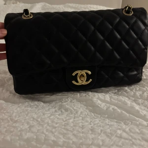 Svart quiltad väska  - Svart quiltad väska med guld detaljer. Bra skick