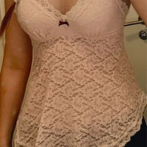 Odd molly spetslinne - Rosa Spetslinne från Odd Molly med röd rosett. Står storlek 2 och passar mig perfekt med storlek S.  